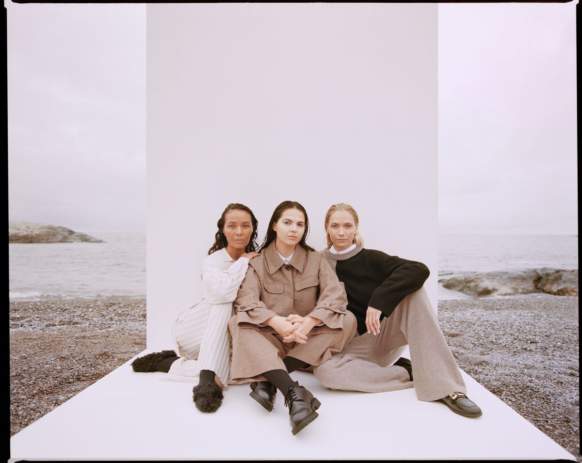 Drei Models in House of Dagmar sitzen vor weißer Leinwand in der Natur.