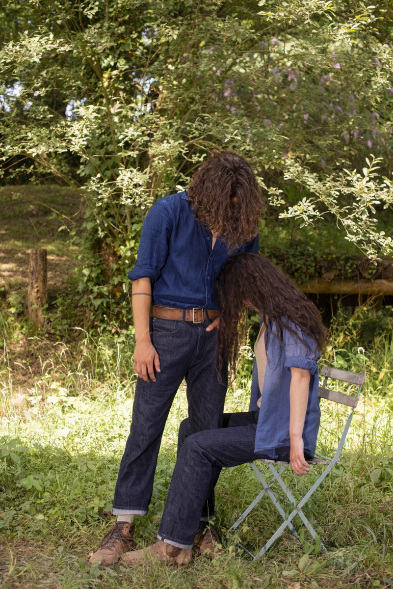 Zwei Models mit dunklen lockigen Haaren in Denim unter einem Baum.